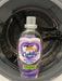 A bottle of Cuddly Refresh Rinse placed inside the drum of a washing machine.